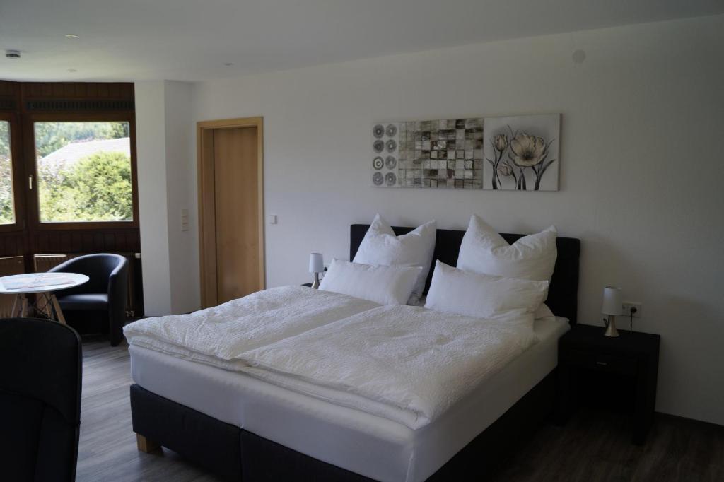 阿尔布斯塔特Am Irrenbächle的卧室配有一张带白色床单和枕头的大床。