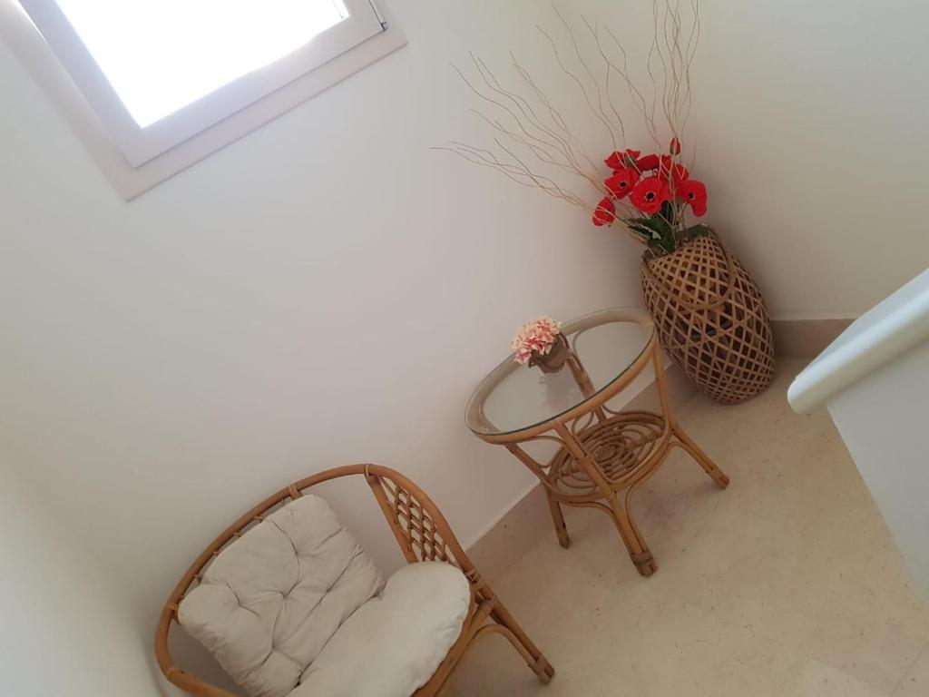 阿韦特拉纳B&b Giadà的一间设有两把椅子和一张桌子的房间和一个花瓶