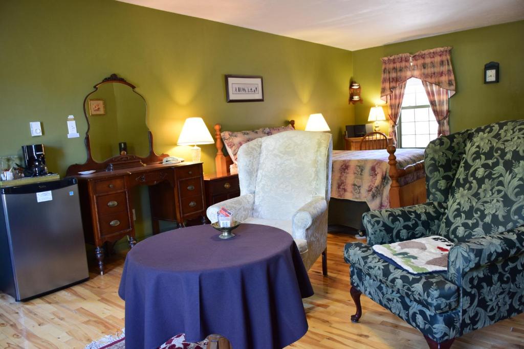 蒙克顿野玫瑰客栈的一间带桌子的客厅和一间卧室