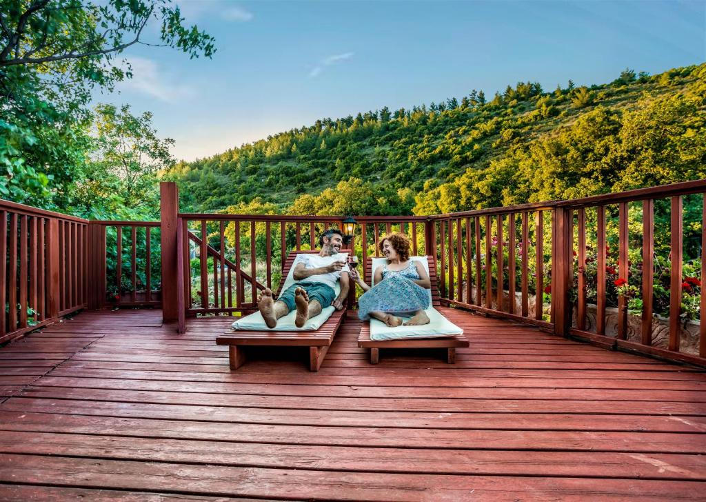 埃米瑞姆树林中的Spa - 阿米灵住宿加早餐旅馆的坐在甲板上床边的男人和女人