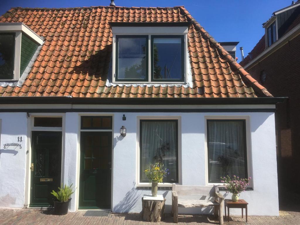 梅登布利克Vissershuisje / old fishermans house的白色的房子,设有窗户和屋顶