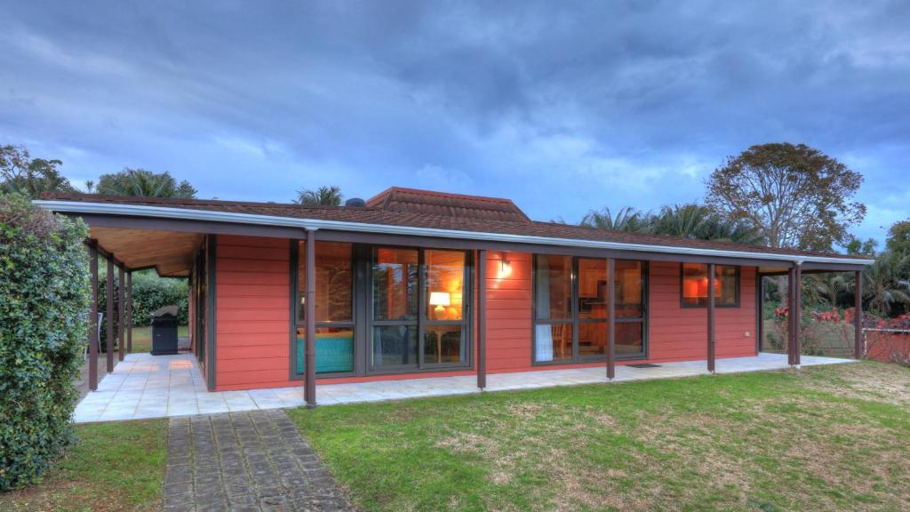彭特派因诺福克岛埃尔杜度假屋的一间红色的房子,设有玻璃门和院子