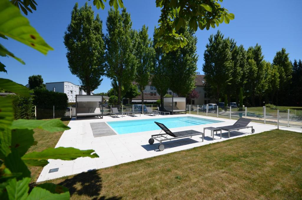 第戎基里亚德迪容东米兰德酒店的庭院旁的游泳池,设有2个长椅