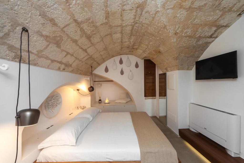 莫诺波利Palazzo Fiscaiolo的一间卧室设有一张带石质天花板的大床
