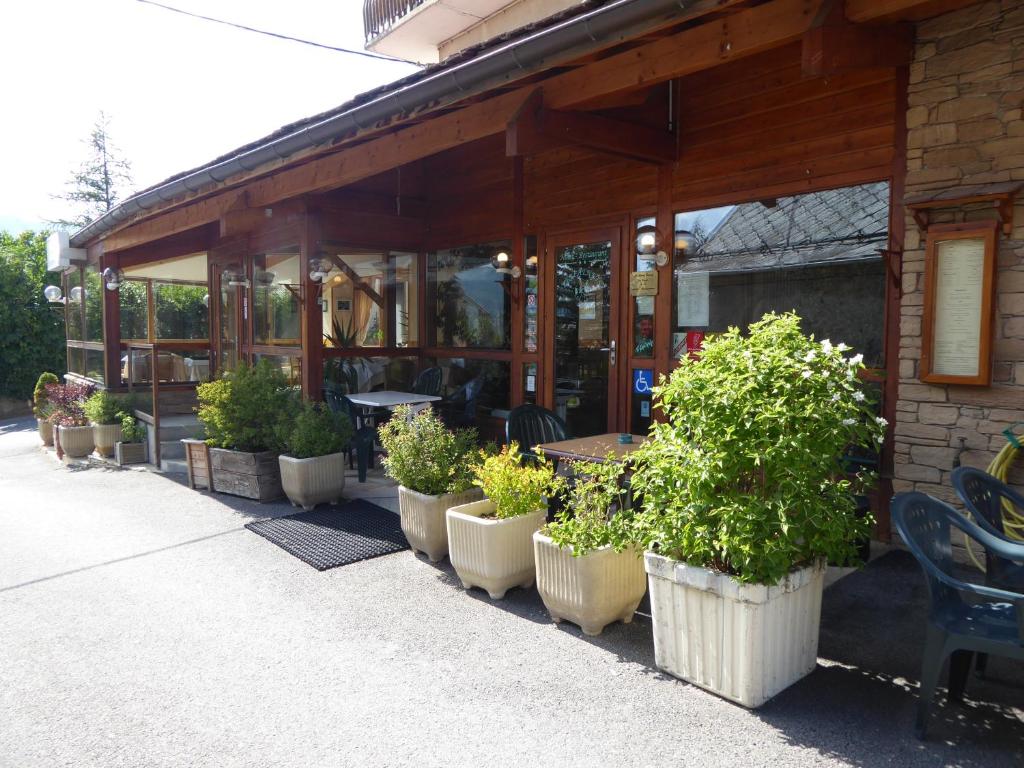 Saint-Julien-en-Champsaur莱斯柴纳茨酒店的餐馆外一排盆盆栽植物