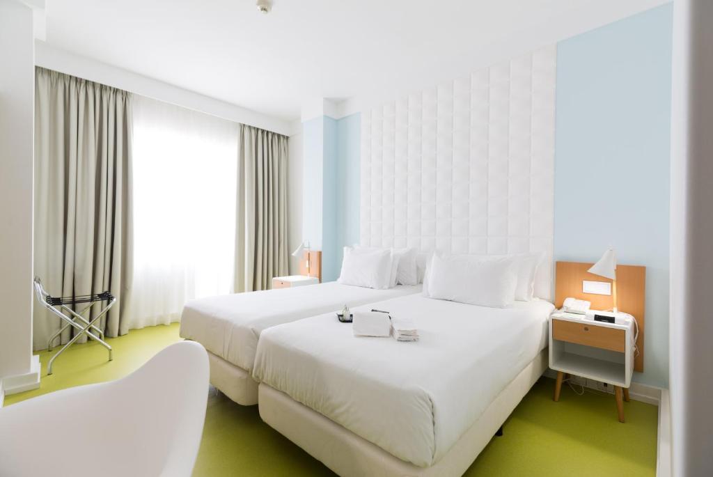 波尔图Legendary Porto Hotel的酒店客房设有一张白色大床和窗户。