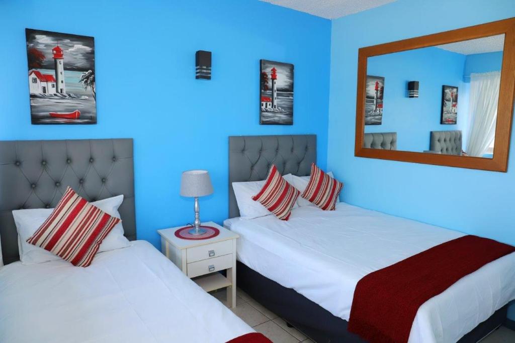 阿曼济姆托蒂Sea Wave Holidays - Stella Maris的蓝色的客房配有两张床和镜子
