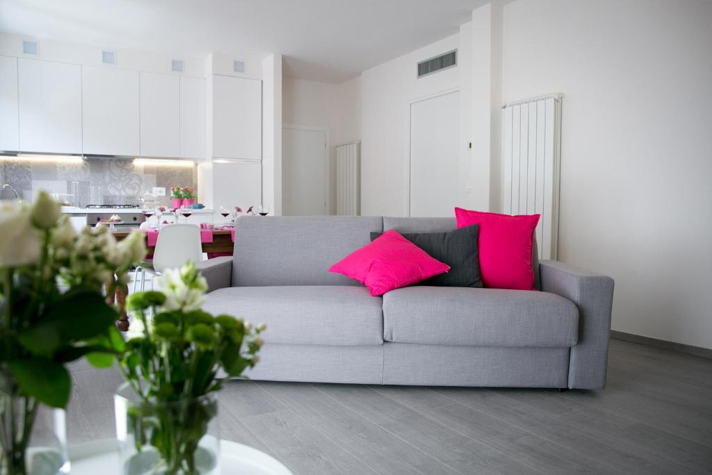 科斯塔沃尔皮诺ML House的客厅配有带粉红色枕头的灰色沙发