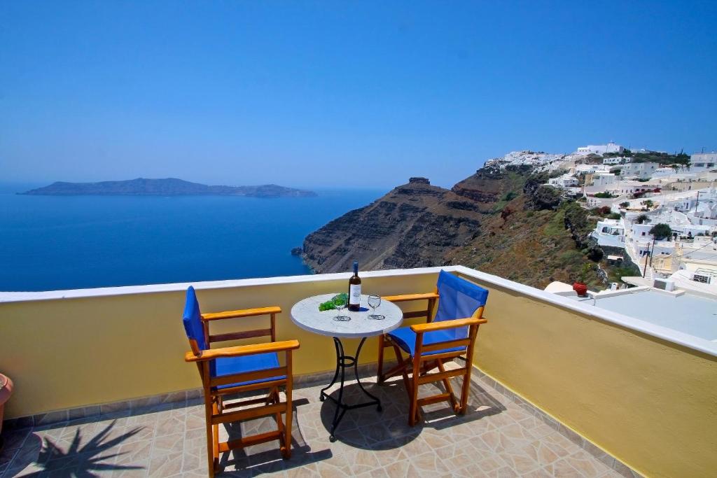 菲罗斯特法尼米洛奥斯酒店的俯瞰大海的阳台配有桌椅