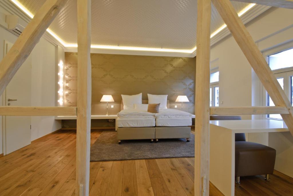 杜塞尔多夫海尔维套房酒店的阁楼卧室配有两张床和一张书桌