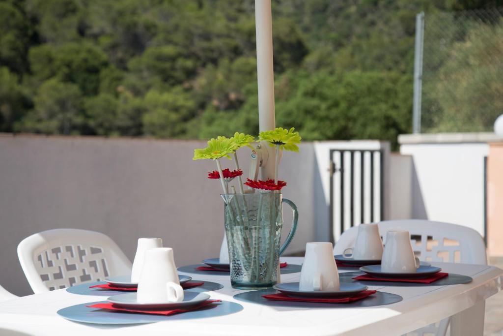 滨海托萨Home Family的一张桌子,上面有盘子和花瓶