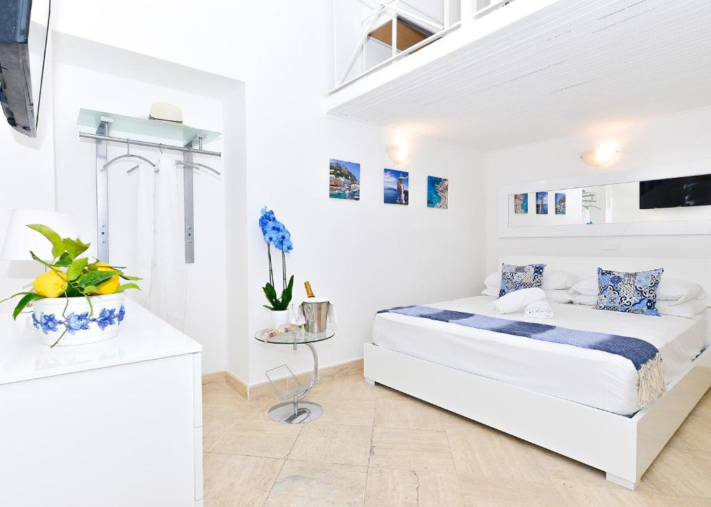 卡普里La Perla Blu的一间白色卧室,卧室内配有一张床
