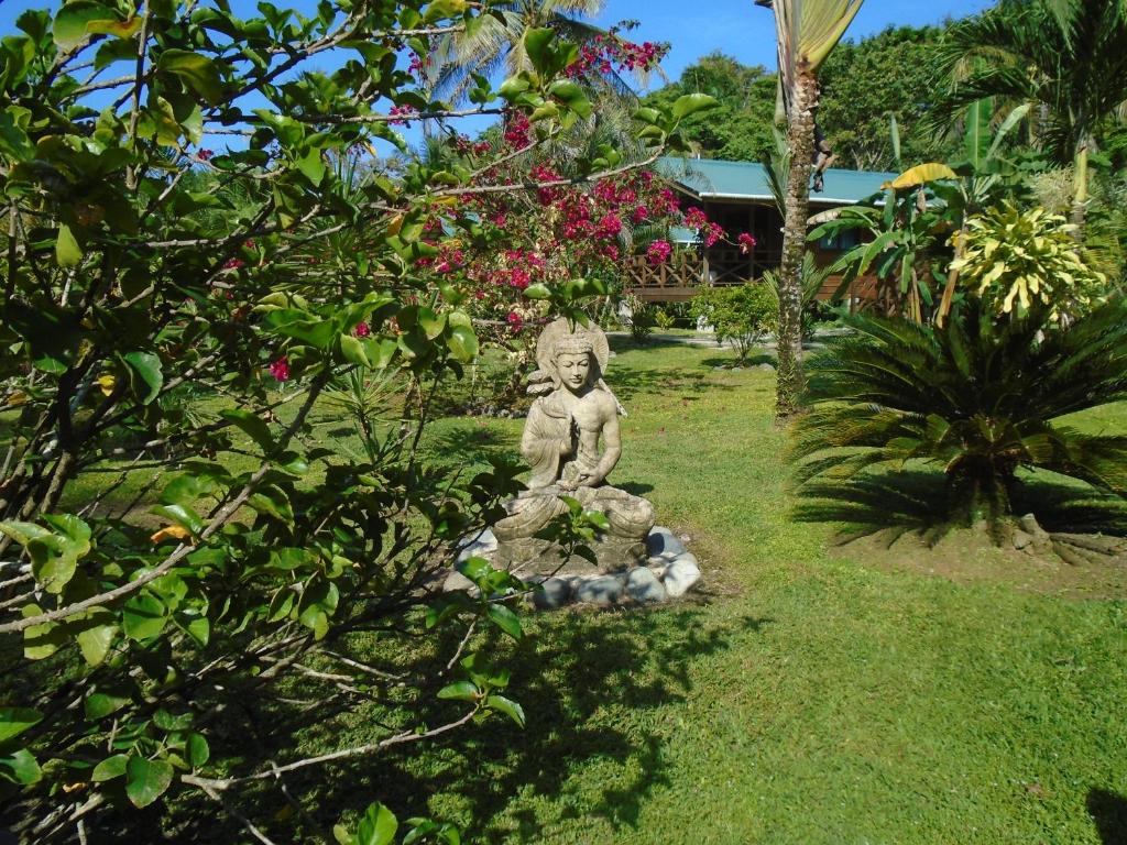 博卡斯德尔托罗J and H Garden Cabinas的猴子坐在草地上的岩石上的雕像