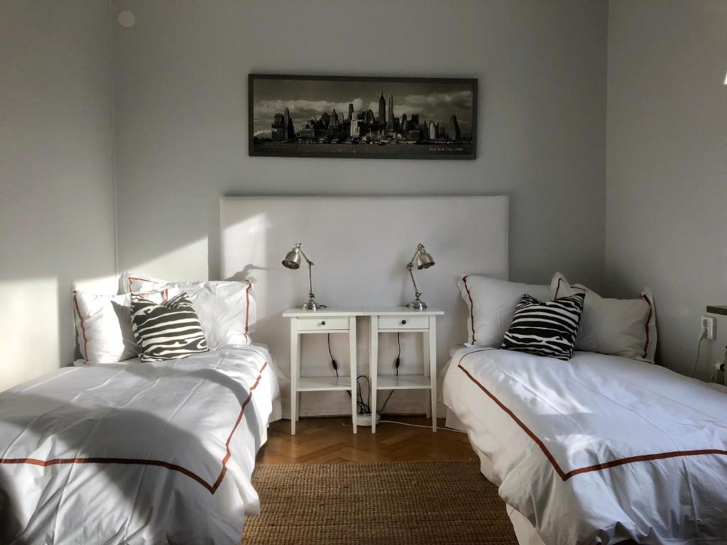 斯德哥尔摩Central Stockholm with Free Airport Pickup的一间卧室设有两张床和一张墙上的桌子。
