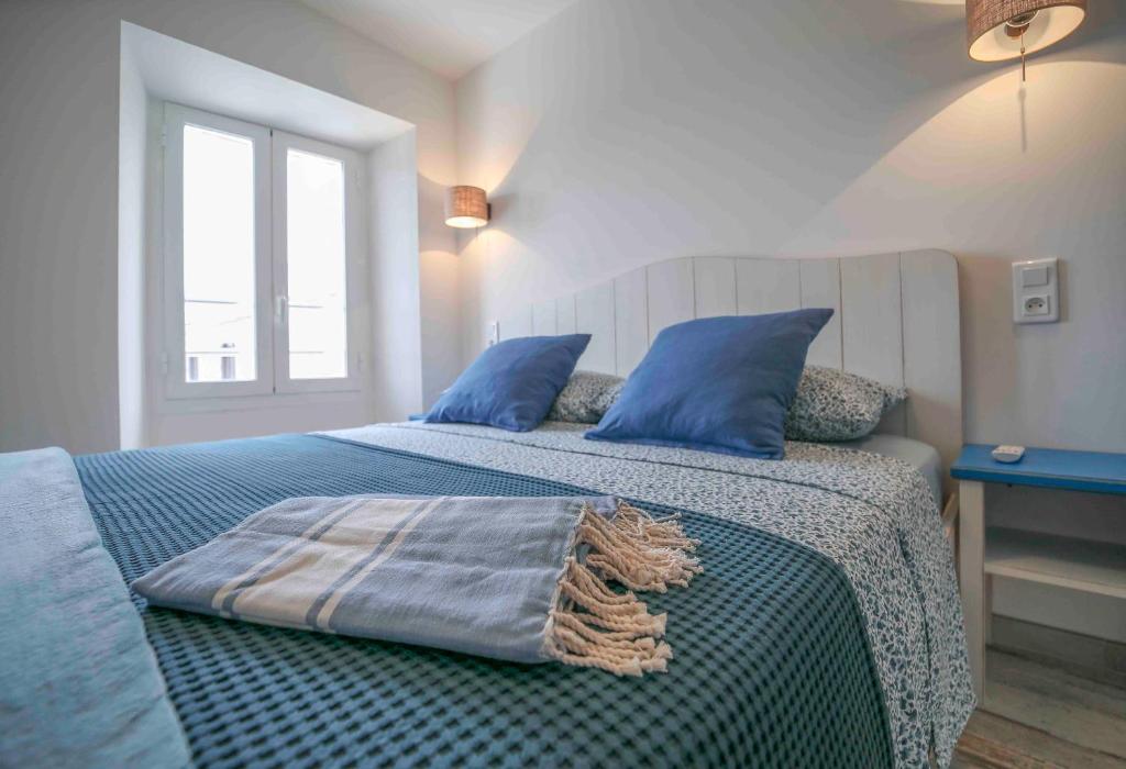 博尼法乔Faro della Madonetta的一张带蓝色枕头的床和一张毯子