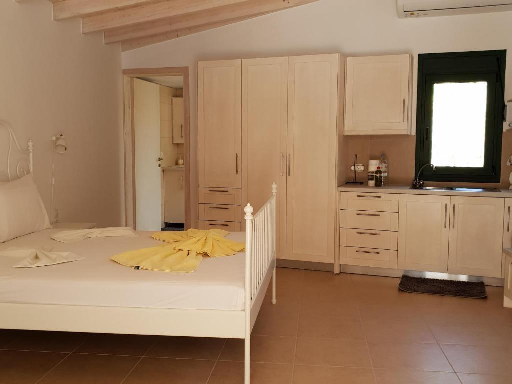 马塔拉Studio Veroniki的一间卧室配有一张白色的床,上面有黄色的连衣裙