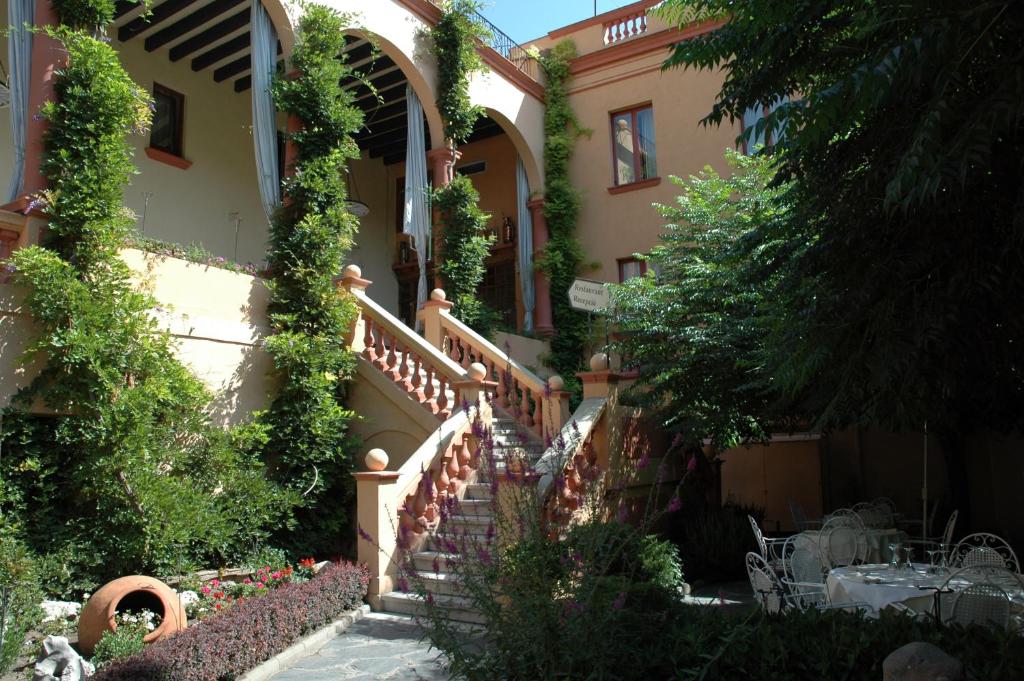 塞奥-德乌赫尔Hotel Andria的一座房子,有楼梯和常春藤