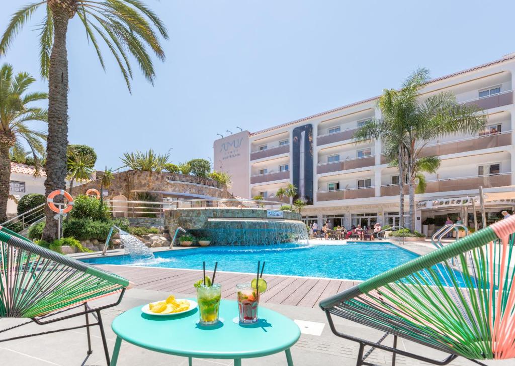马尔格莱特德玛Sumus Hotel Monteplaya & SPA 4Sup - Adults Only的享有游泳池的景色,设有两把椅子和一张带饮料的桌子