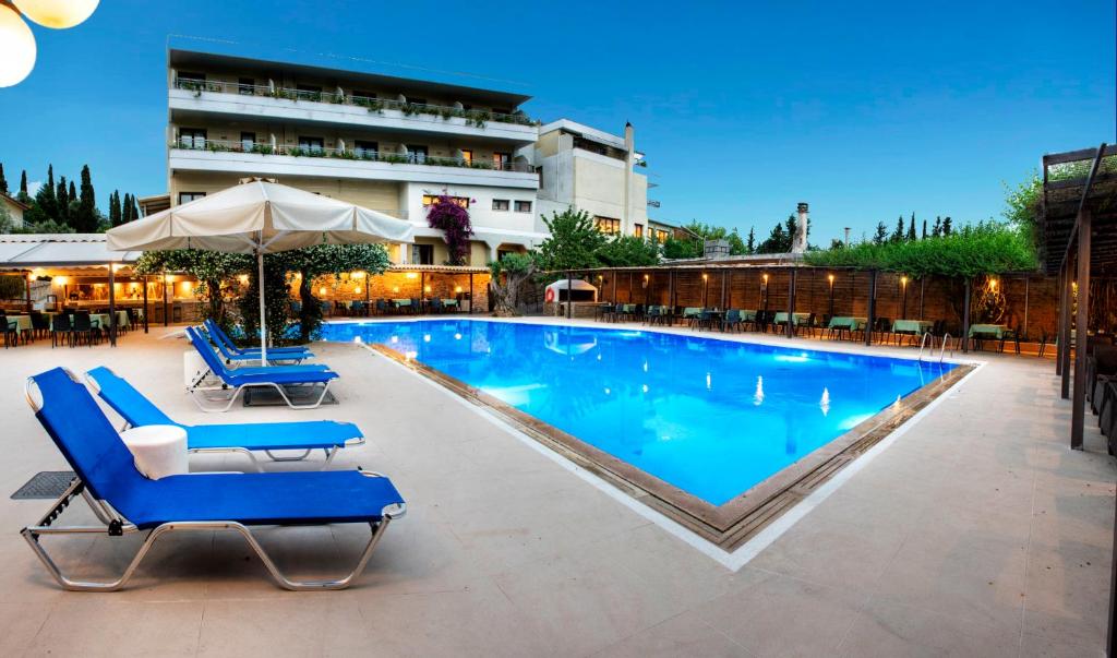 埃雷特里亚米拉马尔酒店的一个带蓝色躺椅和遮阳伞的游泳池