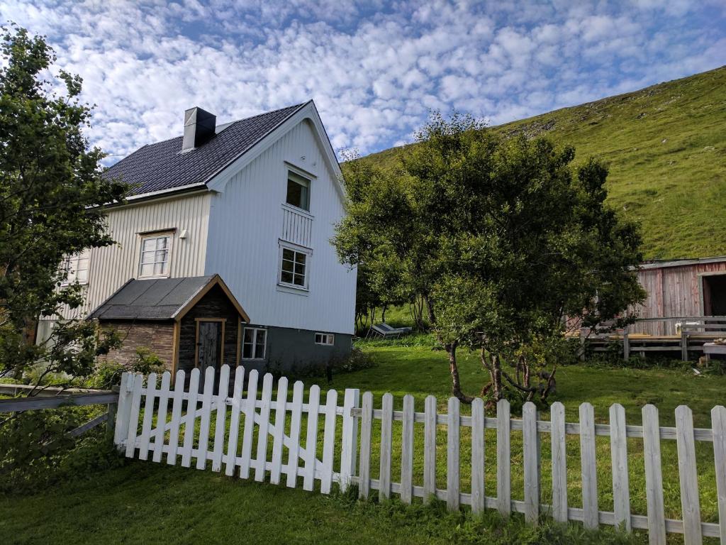SkarsvågNorth Cape family lodge的白色房屋,设有白色的栅栏
