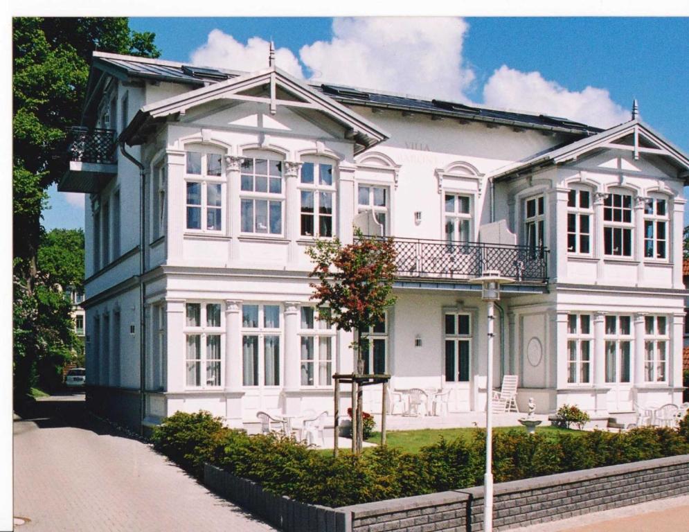赛巴特班森Villa Baroni BF nur 200m vom Ostseestrand entfernt的一间白色的大房子,在街上有白色的窗户
