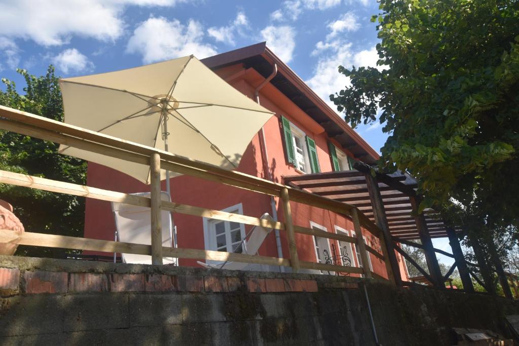 斯培西亚Casa di Dino alla Brusa的坐在大楼边的一把大白伞