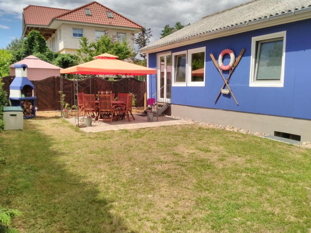 滨湖克拉科Haus der 16 Seen的蓝色的房子,配有桌子和雨伞
