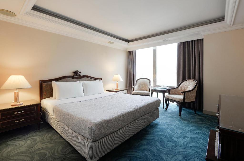 台中市富比世大饭店的配有一张床和一张书桌的酒店客房