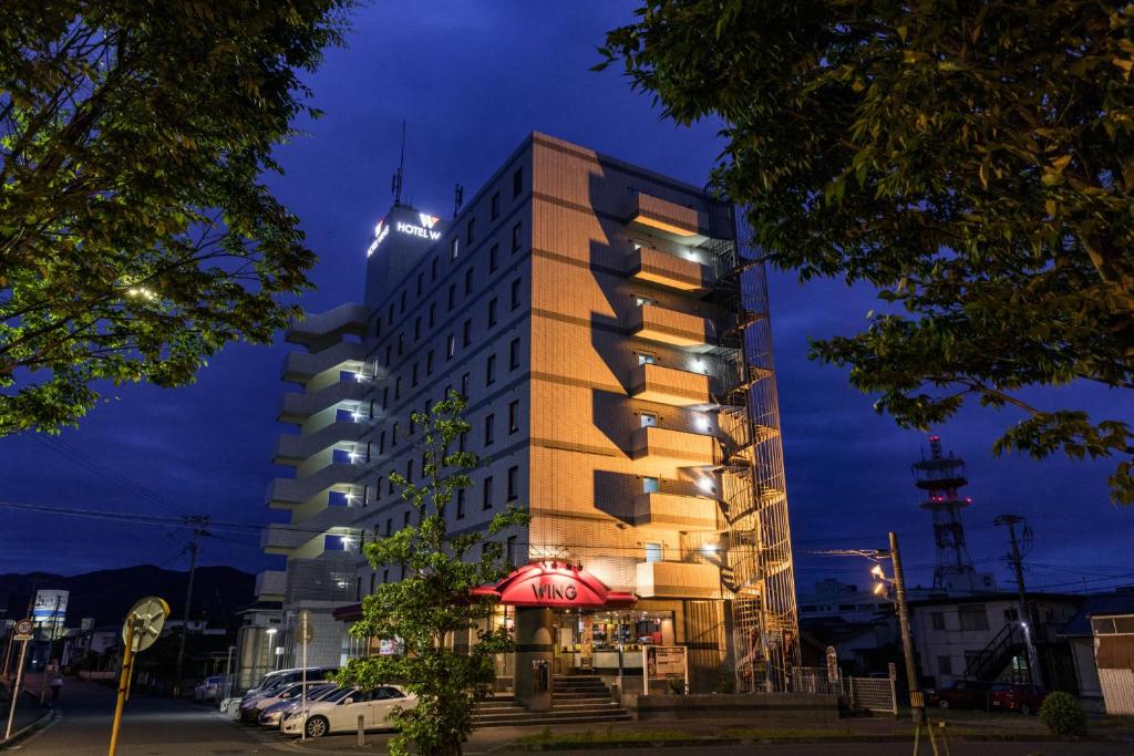 Izumi出水国际酒店的一座高大的建筑,前面有一间餐厅