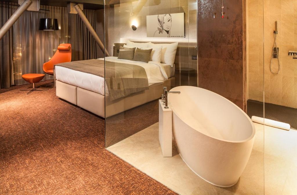 布拉索夫可龙威尔布拉索夫酒店的一间位于床边的带浴缸的浴室