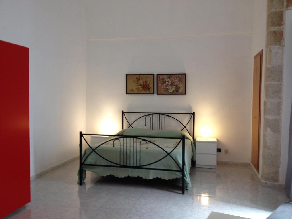 滨海波利尼亚诺Dimora Tarantini的卧室配有一张墙上有两张照片的床。