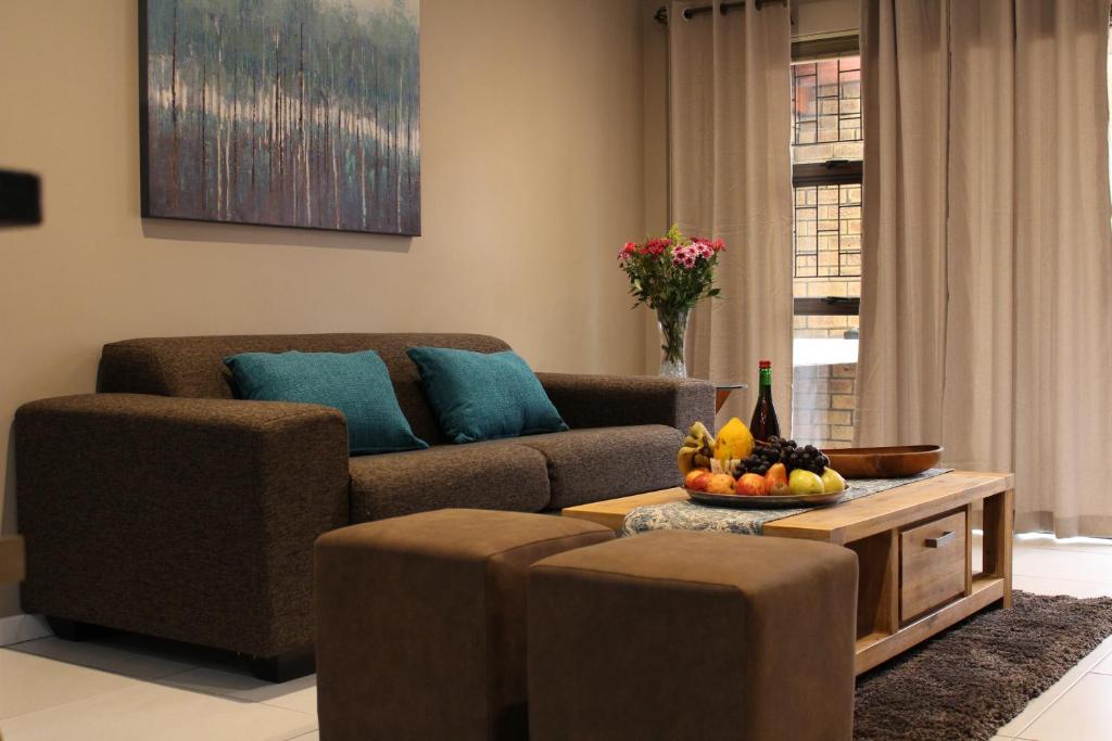 德班维尔DCS Accommodation Cape Gate的客厅配有沙发和带水果的桌子