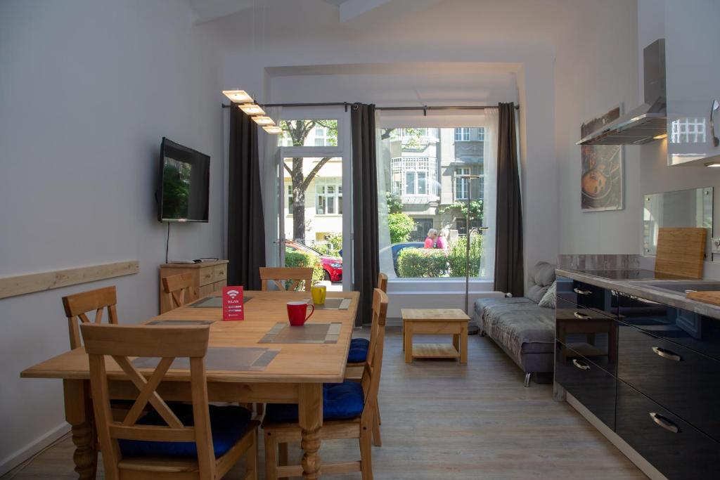 柏林Pandoras home的厨房以及带桌子和沙发的客厅。