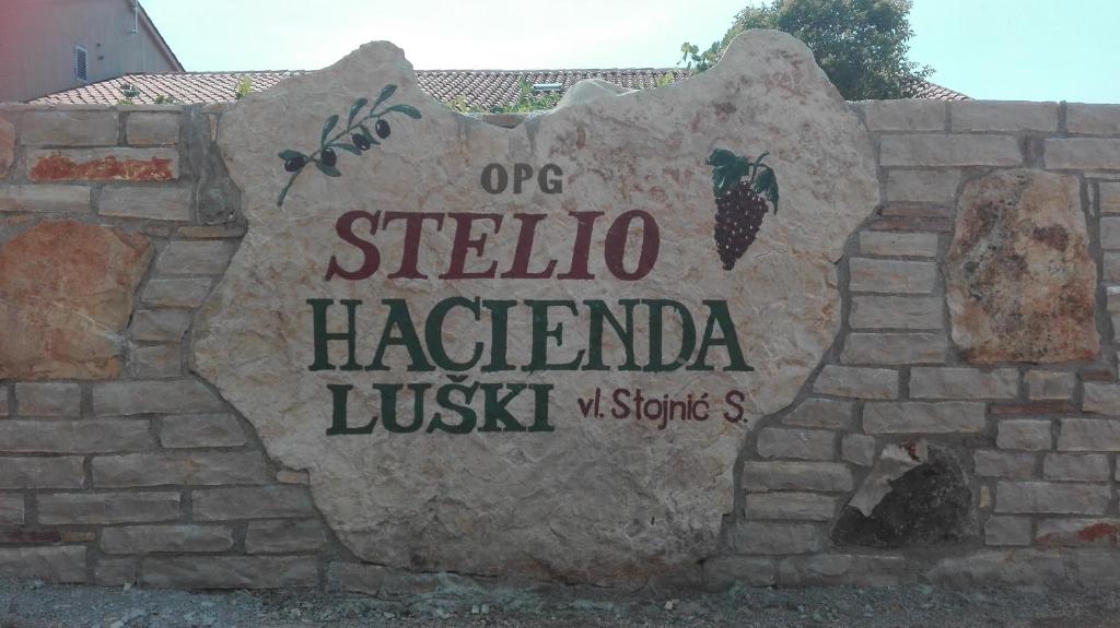 波雷奇Apartment and Rooms Hacienda Stelio的砖墙上的一个标志,上面写着一个西巴庄园