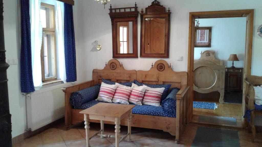 迈泽克韦什德Nosztalgia Vendégház的客房设有带枕头的沙发和桌子。