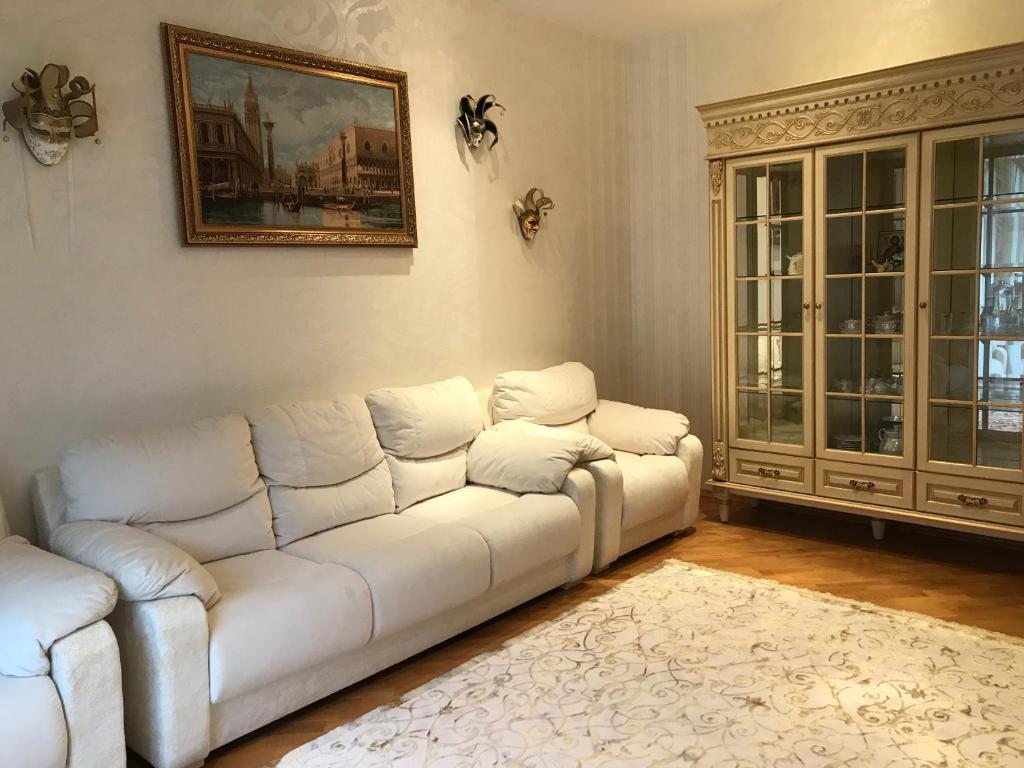 捷尔诺波尔Дворівневі Апартаменти Antique的客厅配有白色沙发和绘画作品
