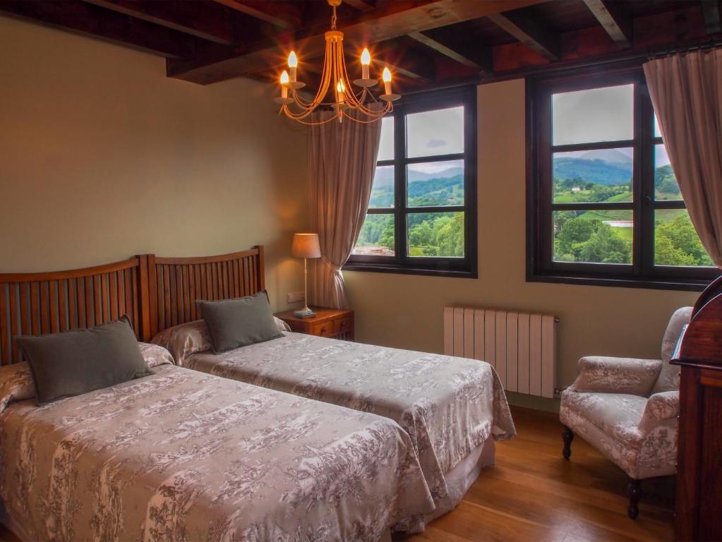 因菲耶斯托Casas Rurales Asturias Campon Antrialgo的一间卧室配有一张床、一把椅子和窗户。