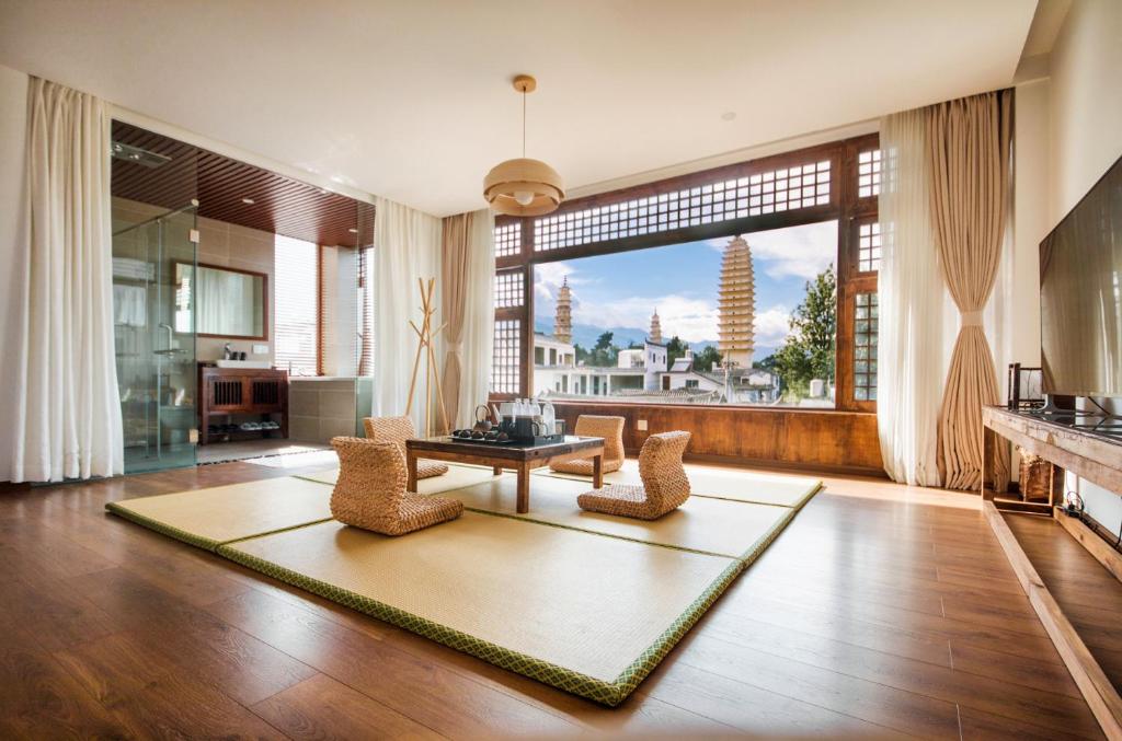 大理Dali Rong lu Hotel的客厅配有桌椅和大窗户