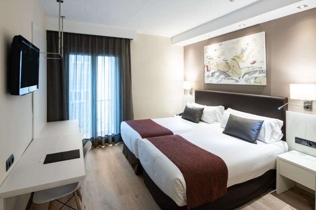 巴塞罗那加泰罗尼亚卡斯特诺酒店的配有一张床和一台平面电视的酒店客房