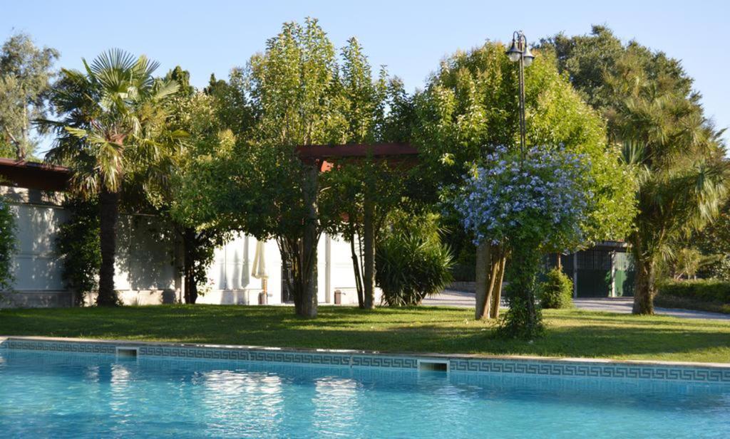 佩纳菲耶尔昆塔帕德拉奥乡村民宿的一座树木繁茂的房屋前的游泳池
