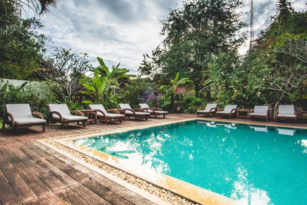 邦隆红土上的小屋酒店的一个带躺椅的游泳池和一个游泳池