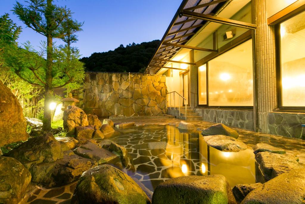 下关Ichinomata Onsen Kanko Hotel的一座建筑前有池塘的房子