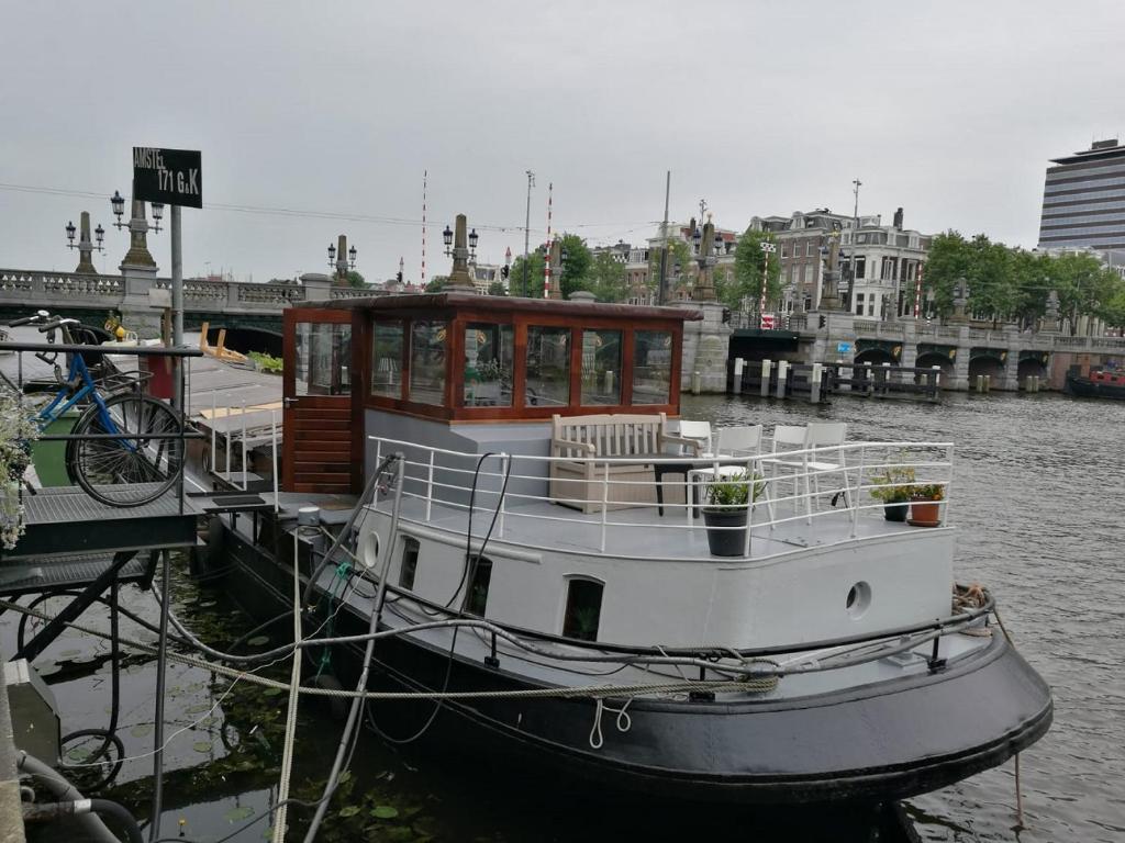 阿姆斯特丹houseboat Rose的船停靠在水面上的码头