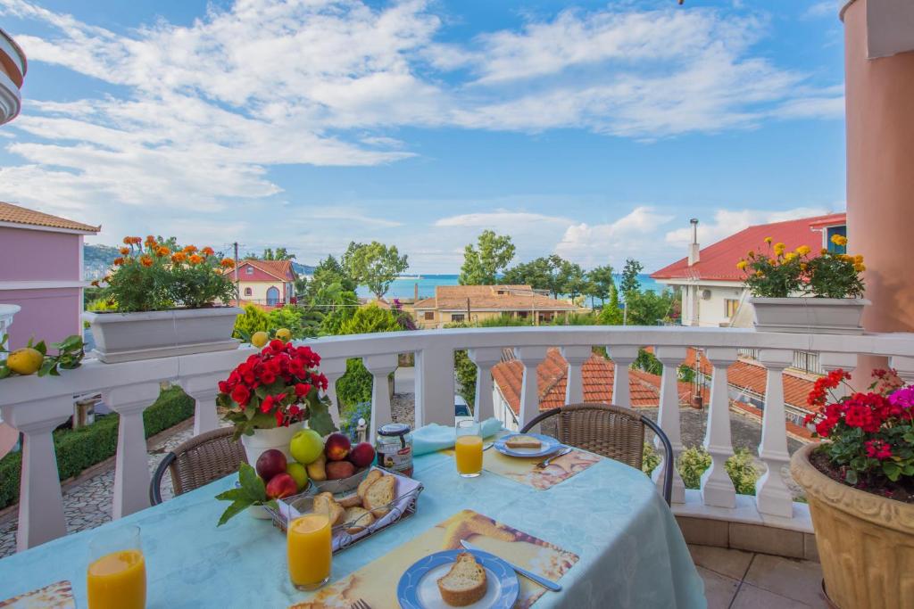 扎金索斯镇Zante View (4bedroom luxury home) Free Pickup的阳台上的桌子上摆放着食物和水果
