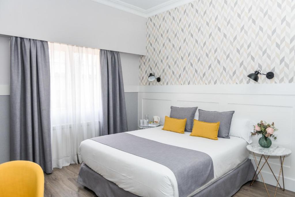 马德里BYPILLOW Velázquez 45的酒店客房配有一张带黄色枕头的大床