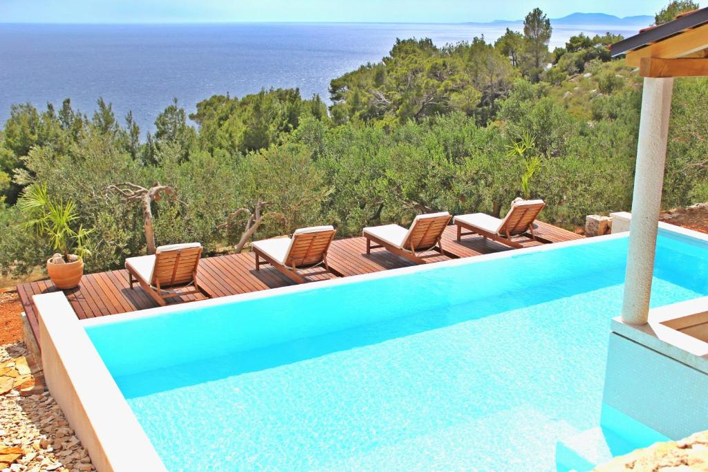 圣内德尔贾Villa Perka的一个带椅子的游泳池,背景是大海