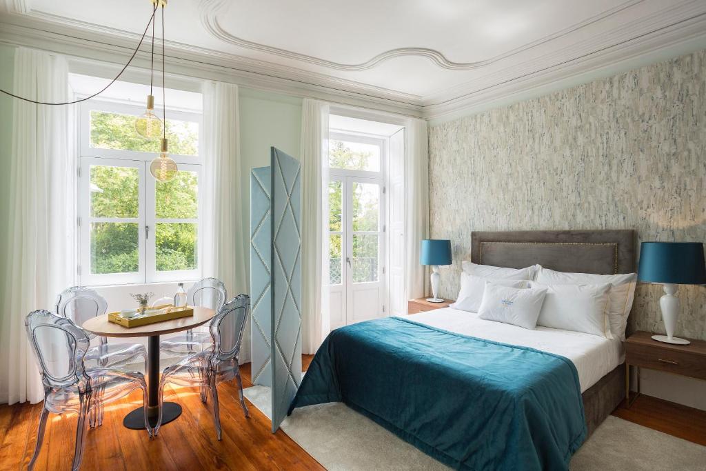 波尔图杜罗宫普里蒂卡多斯旅馆的卧室配有床、桌子和窗户。