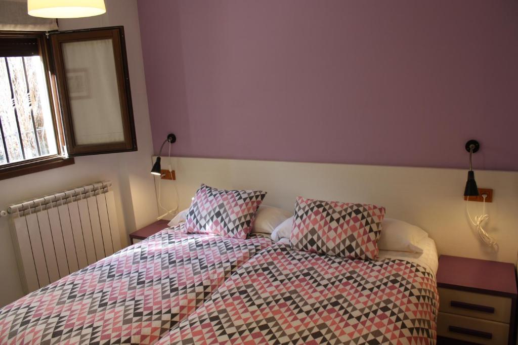 昆卡纳里贝拉德尔胡卡尔旅馆的卧室内的一张带被子和枕头的床