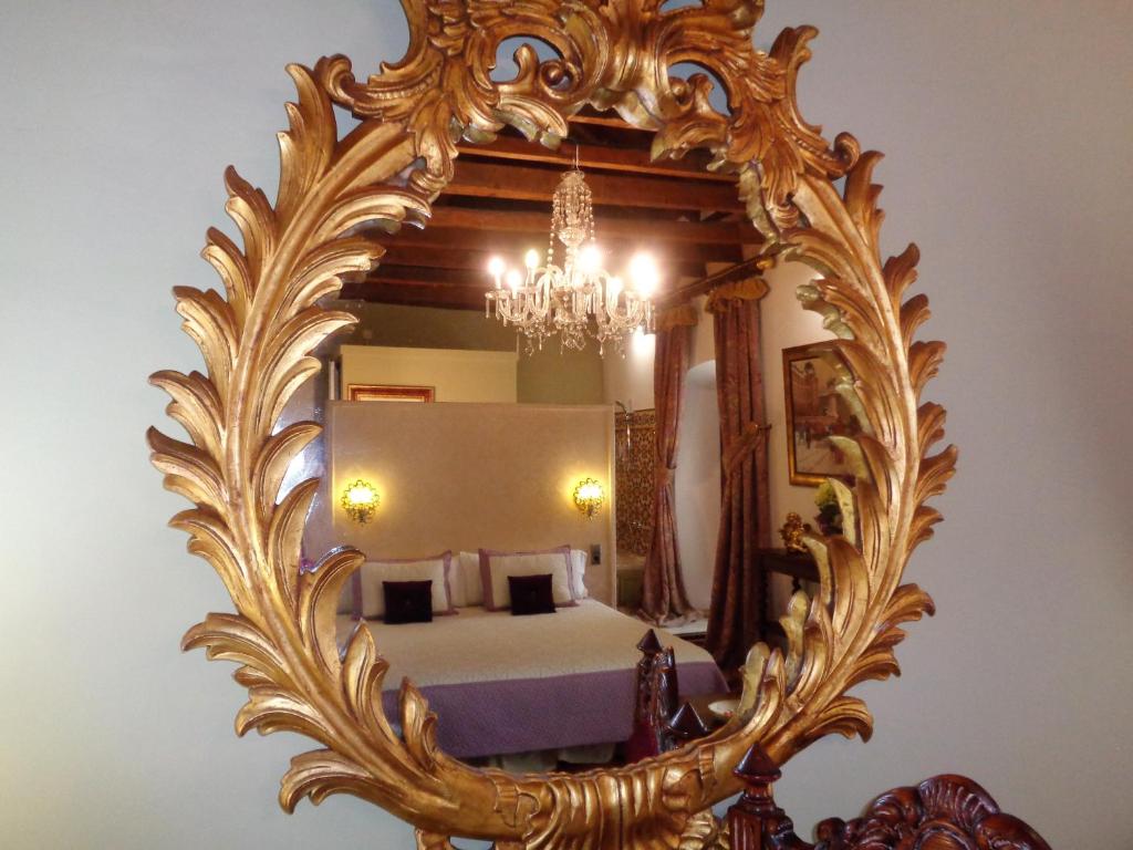 乌贝达Hotel Boutique Nueve Leyendas的卧室内的金色镜子和床