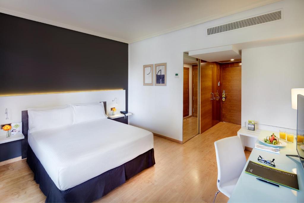 巴达霍斯苏尔巴然斯考特大酒店的配有一张床和一张书桌的酒店客房